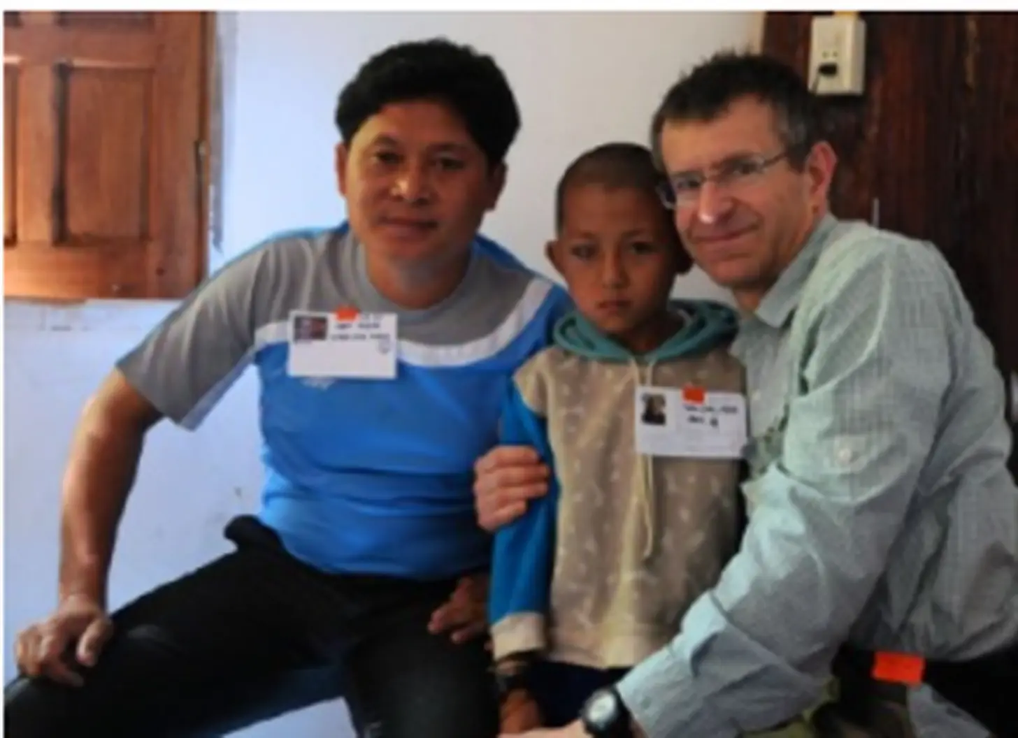Two eye-care professionals supporting a young patient during a humanitarian mission